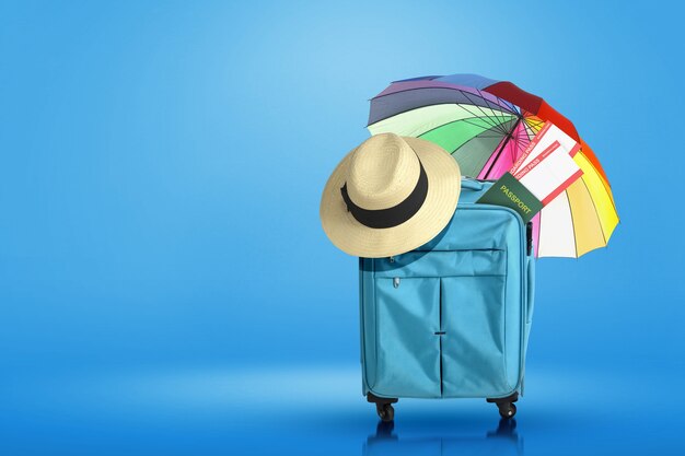 Blauer Koffer, Hut, Ticket und Reisepass mit Regenschirm mit farbigem Hintergrund