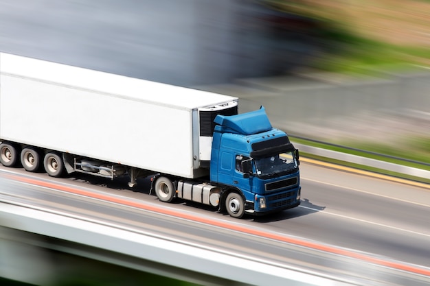 Blauer LKW auf Brücke mit unscharfem Hintergrund