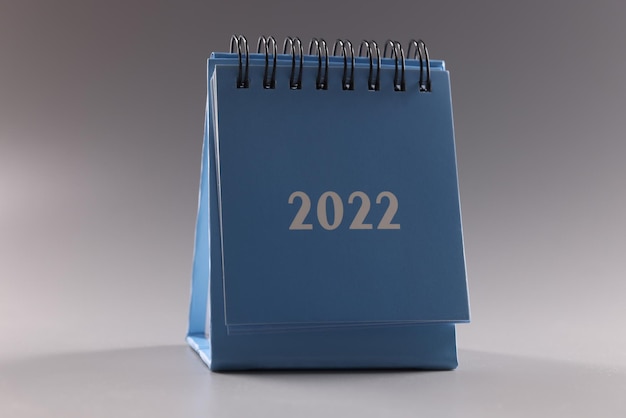 Blauer Loseblattkalender auf grauem Hintergrund