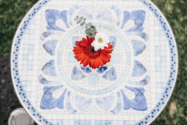 Blauer Mosaiktisch mit Blumen im Garten