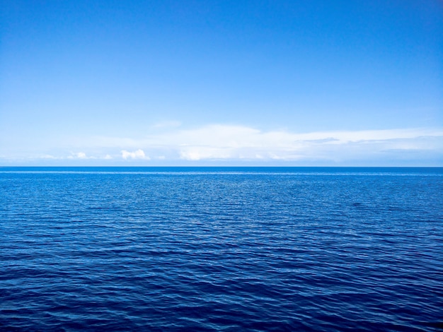 Blauer Ozean und Himmel mit Clous am Horizont