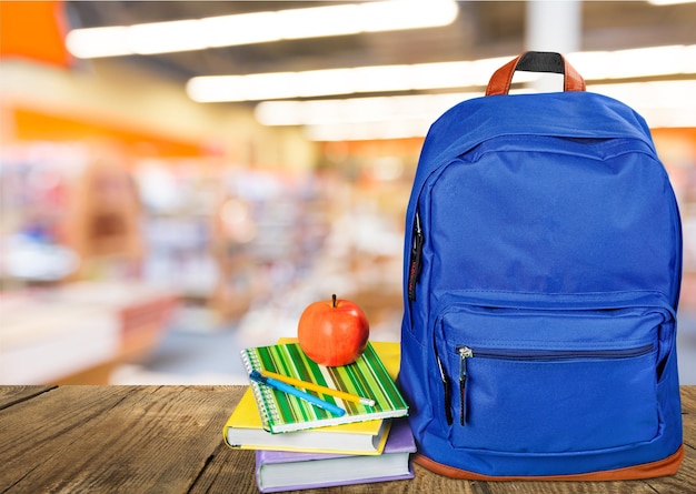 Blauer Schulrucksack im Hintergrund.