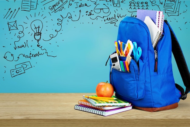 Blauer Schulrucksack im Hintergrund.