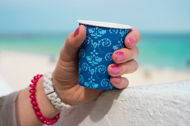 Blauer Tasse Kaffee in einer weiblichen Hand