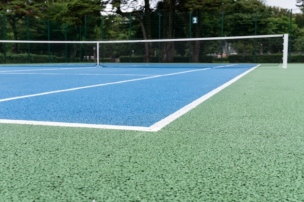 Blauer Tennisplatz. Sonniger Tag im Freien. Tennis-Konzept. Kopieren Sie Platz