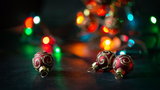 Blauer und silberner Weihnachtsball auf beleuchtetem Hintergrund der dunklen Girlande.