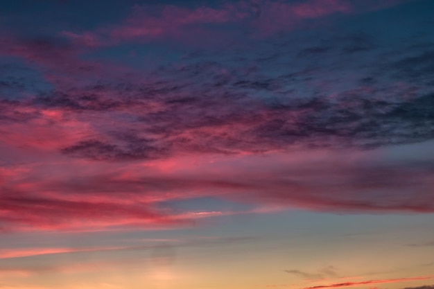 Blauer violetter roter Sonnenuntergang Himmelshintergrund mit flauschigen, lockigen, rollenden Cirrostratus-Wolken am Abend Gutes windiges Wetter