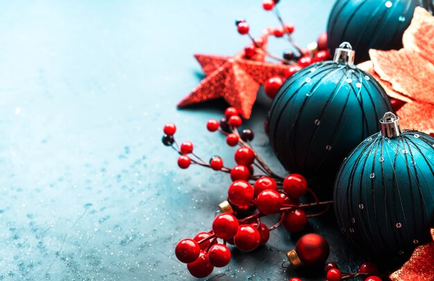 Blauer Weihnachts- oder Neujahrs-Hintergrund mit blauen weihnachtskugeln, roten Beeren und Sternen