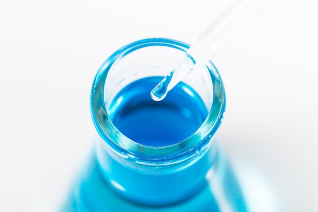blauer Wissenschaftsexperimentkolben auf weißem Hintergrund, Reagenzgläser mit blauer Flüssigkeit lokalisiert auf Weiß