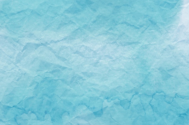 Blaues Aquarell auf zerknittertem Papier, das als Hintergrund nützlich ist