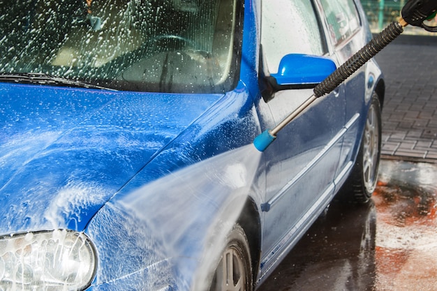 Blaues Auto in einer Autowäsche