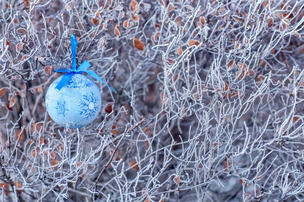 Blaues Ballweihnachtsspielzeug auf einem Weihnachtsbaumzweig Weihnachten im Stadthintergrund für neues Jahr