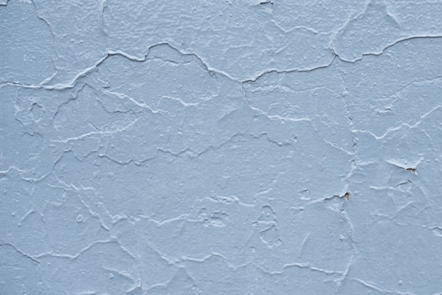 Blaues Brett mit Rissen von der Farbe. Alte Mauer Hintergrund.
