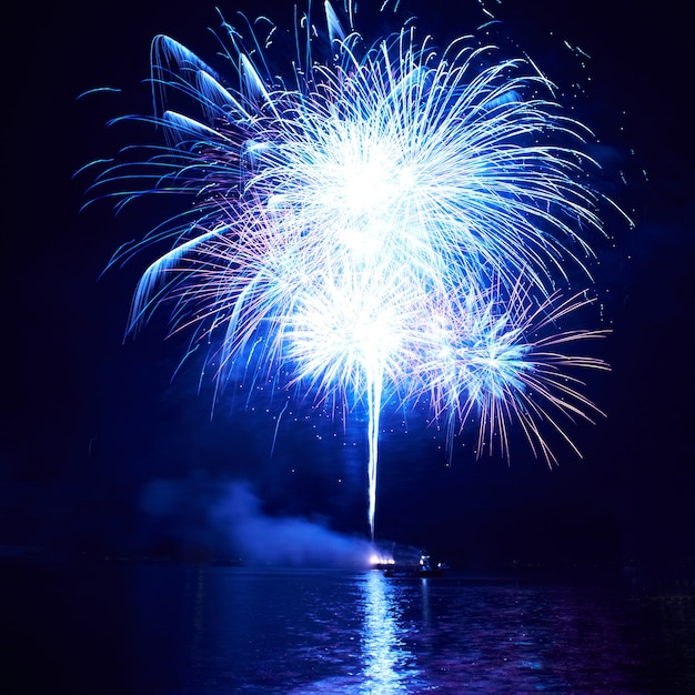 Blaues buntes Feuerwerk auf dem schwarzen Himmelhintergrund