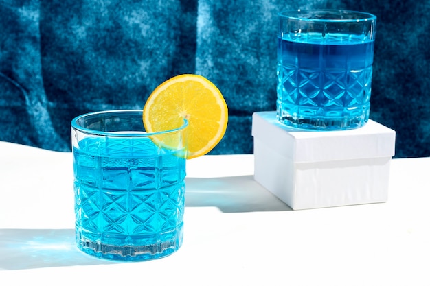 Blaues Cocktailgetränk zwei Gläser mit blauem Getränk in Orange gefärbt