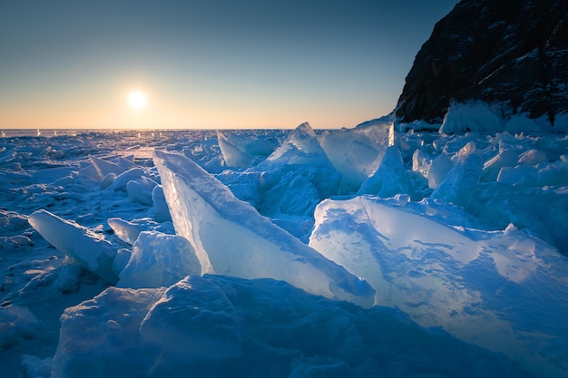 Blaues Eis auf dem Baikal-See bei Sonnenaufgang am Kap Khoboy der Insel Olkhon im Baikal in Russland.