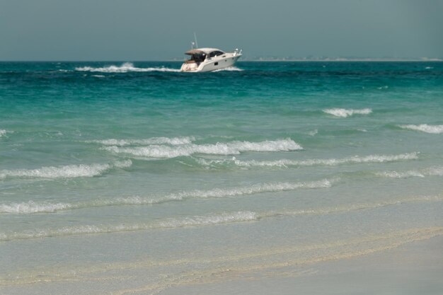 Foto blaues klares meer yacht wasserwellen klarer himmel strand auf der insel saadiyat vereinigte arabische emirate