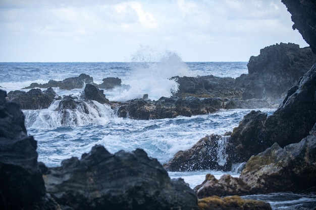 Blaues Meer und Felsen stürmen Wellenspray über Felsen felsige Meeresküste