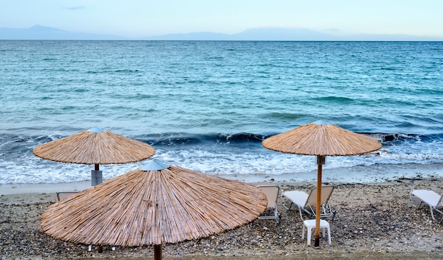 Blaues Meer und Strand mit Sonnenschirmen in Fourka Scala, Chalkidiki, Griechenland