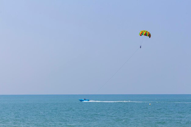 Foto blaues motorboot am horizont in der andamanensee rollt mann unter flachem dof-fallschirmkopierraum