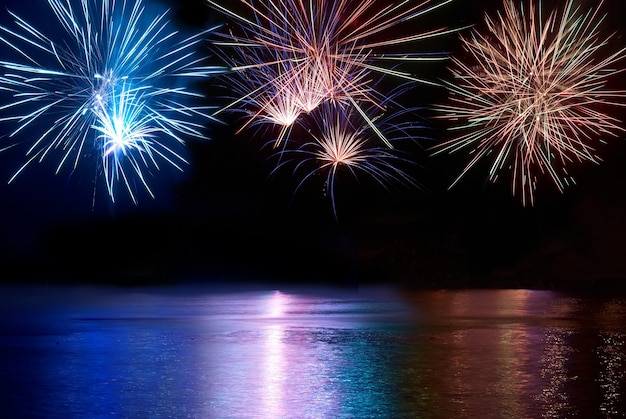 Blaues, rotes und weißes buntes Feuerwerk über dem Fluss. Feiertagsfeier.