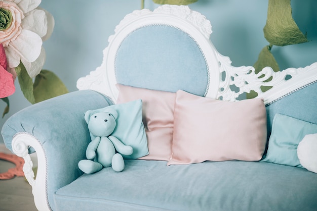 Blaues Sofa mit Kissen und Teddybär