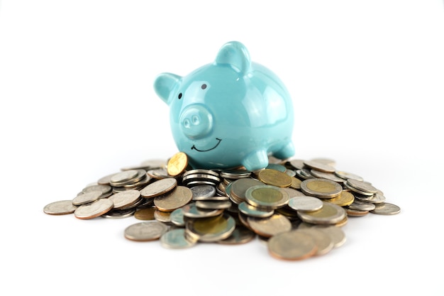 Blaues Sparschwein auf Münzhintergrund zum Sparen von Geldgeschäftskonzept