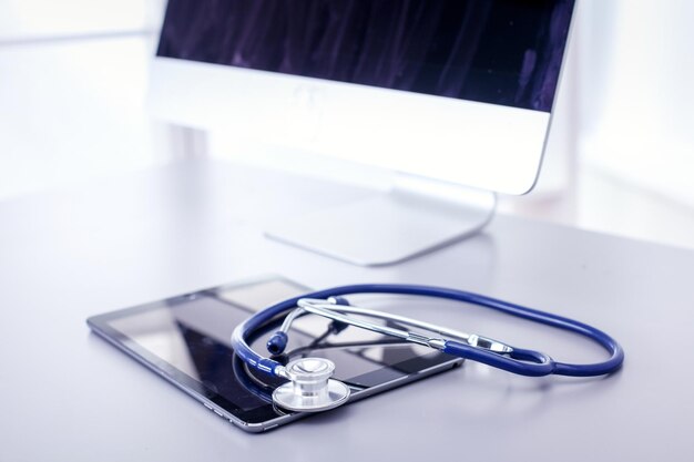Blaues Stethoskop und Tablet der medizinischen Ausrüstung auf weißem Hintergrund medizinische Ausrüstung