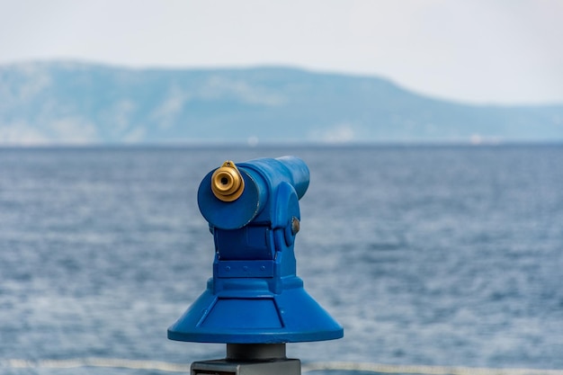 Foto blaues teleskop oder panoramabioskop für touristen mit meerblick