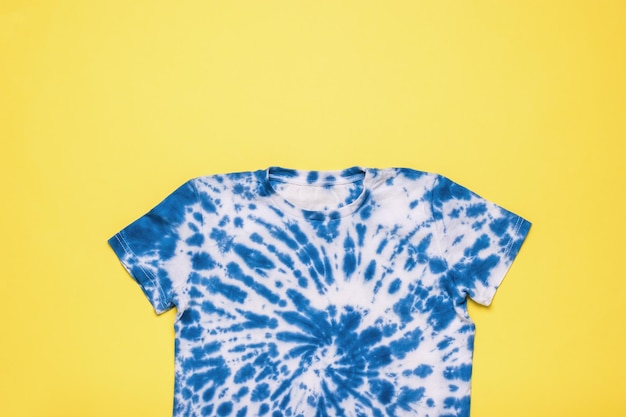 Blaues Tie-Dye-T-Shirt auf gelbem Hintergrund Flach lag