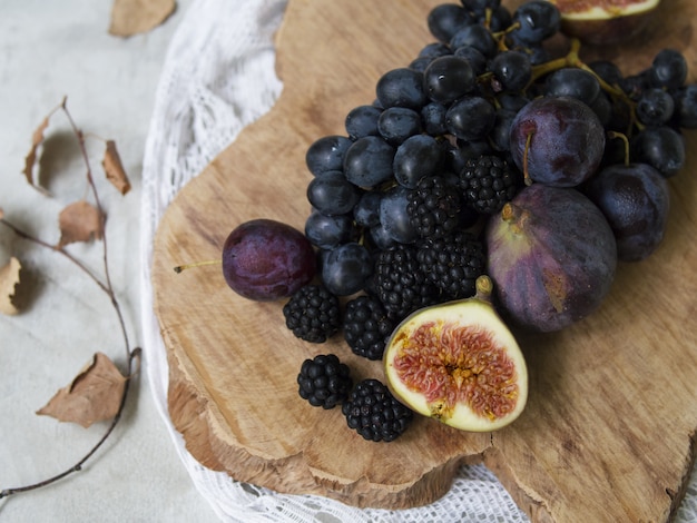 Blaues und lila Essen. Brombeeren, Trauben, Pflaumen, Heidelbeeren. Leckere und reife Früchte und Beeren. Herbst Arrangement von Früchten.