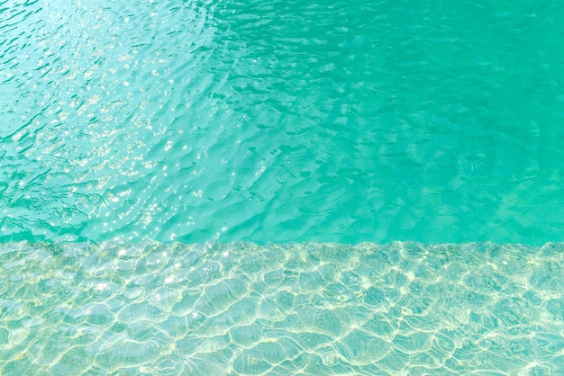Blaues Wasser des Swimmingpools mit Wellen- und Sonnenlichtreflexionseffekt