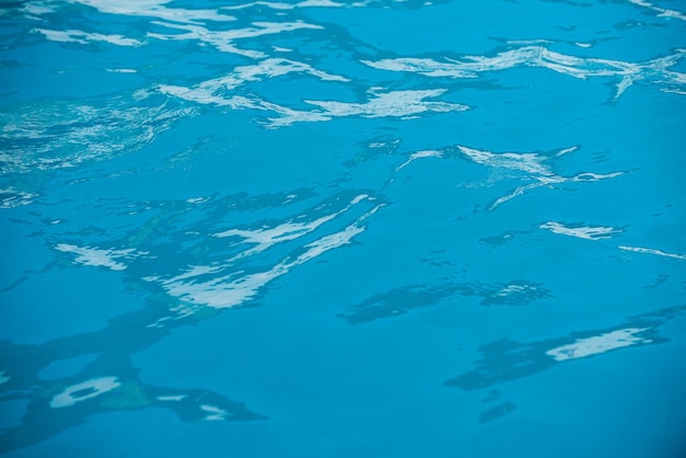 Blaues Wasser des Wasserhintergrundes kräuselt sich und hebt die Beschaffenheit der Wasseroberfläche und des gefliesten Bodens hervor