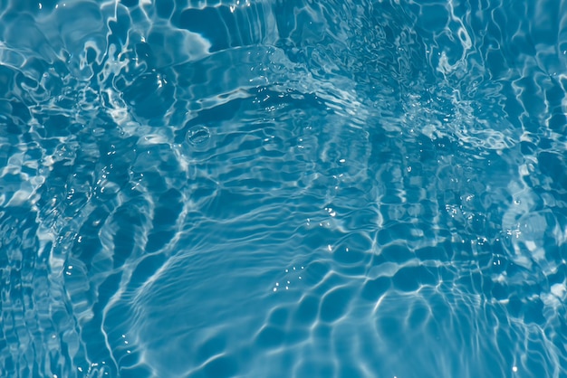 Blaues Wasser mit Wellen auf der Oberfläche Unscharfes, transparentes, blau gefärbtes, klares, ruhiges Wasser