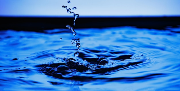 Blaues Wasser spritzt Flüssigkeitstropfen