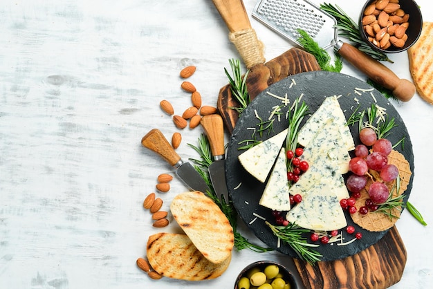 Blauschimmelkäse mit Schimmel auf einem Teller mit Snacks im rustikalen Stil Freier Kopierplatz