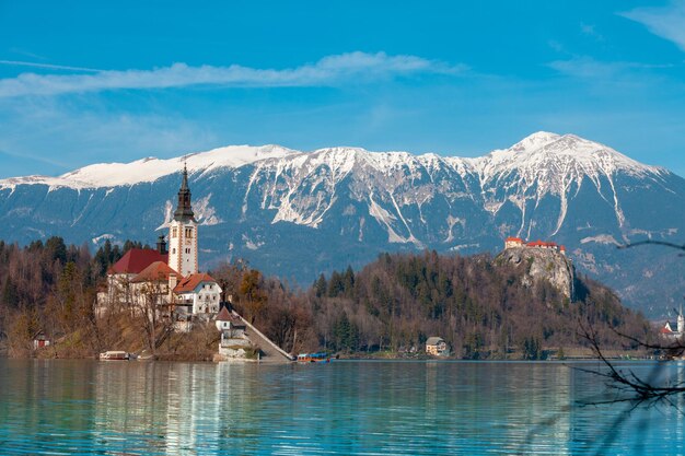 Bleder See gegen schneebedeckte Berggipfel im zeitigen Frühjahr. Slowenien, Europa