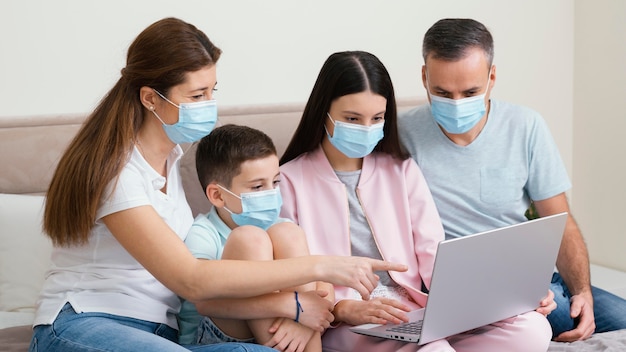 Foto bleiben sie drinnen familie mit medizinischen masken