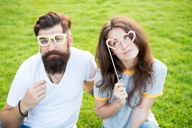 Bleiben Sie konzentriert mit der besten Brille Verliebtes Paar, das durch eine Prop-Brille auf grünem Gras blickt