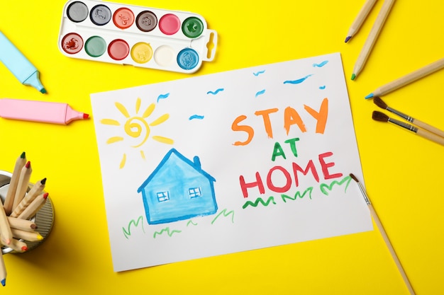 Bleiben Sie zu Hause Konzept auf gelber Oberfläche. Kinderplatz zum Zeichnen