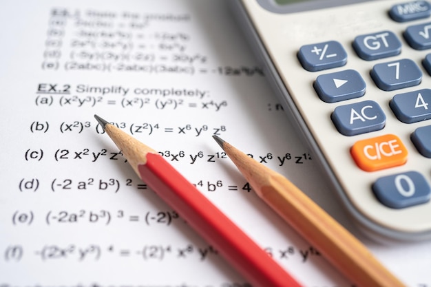 Bleistift und Taschenrechner auf mathematischem Formelübungstestpapier in der Bildungsschule.
