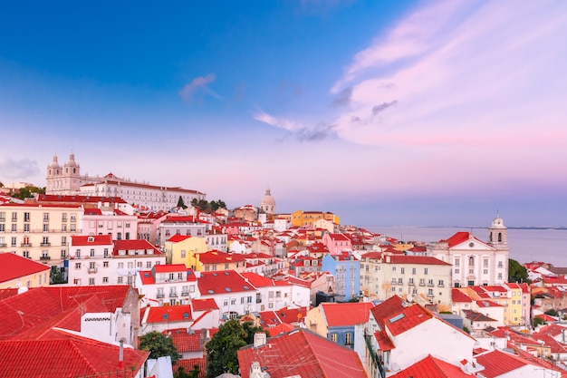 Blick auf Alfama, den ältesten Stadtteil der Altstadt, mit dem Kloster Sao Vicente de Fora, der Kirche des Heiligen Stephan und dem Nationalen Pantheon bei malerischem Sonnenuntergang, Lissabon, Portugal