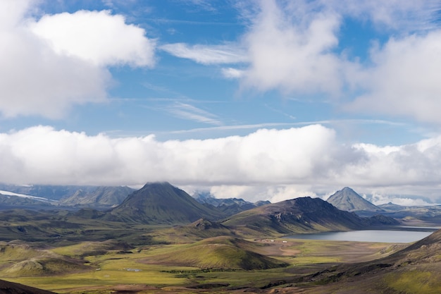 Blick auf das Gebirgstal mit grünen Hügeln, Flussbach und See. Laugavegur Wanderweg, Island.