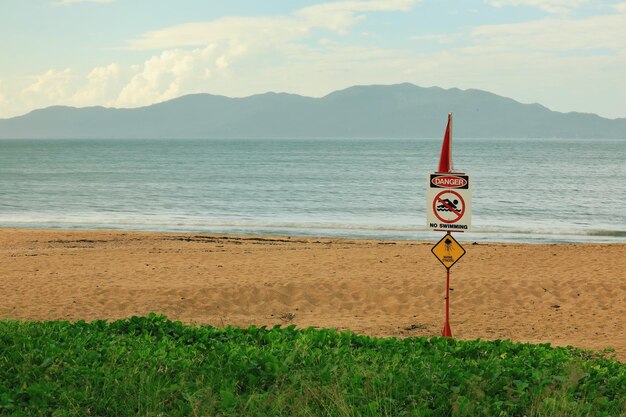 Foto blick auf das schild am strand vor dem himmel