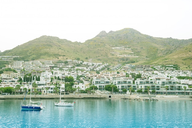 Blick auf das schöne Meer, die Stadt und ein Fischerboot im Turgutreis Bodrum