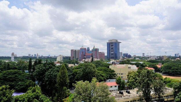 Blick auf das Stadtbild von Bangalore von der Terrasse des Chancery Pavilion Hotel Stadium und Wolkenkratzer wie den Prestige UB City Concorde Block, der durch Grün sichtbar ist