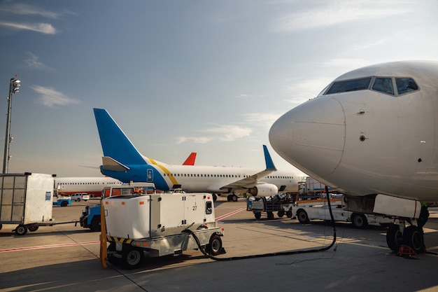 Blick auf das weiße Flugzeug während des Auftankens am Flughafen tagsüber im Freien. Flugzeugdetails. Flugzeug, Versand, Transportkonzept