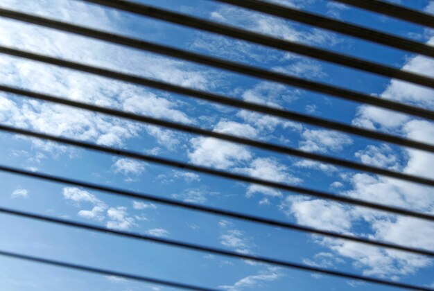 Blick auf den blauen Himmel durch die Jalousie Abstraktion und Hintergründe