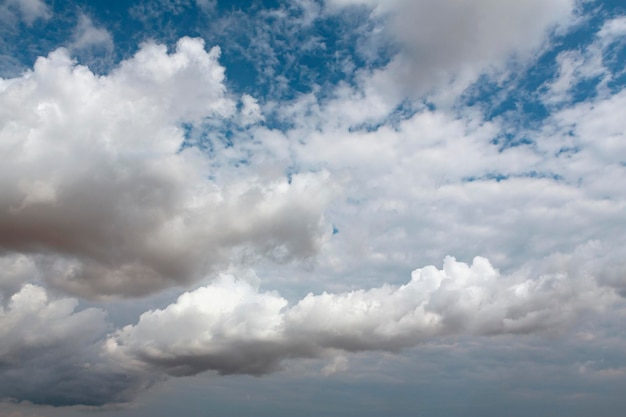 Blick auf den blauen Himmel mit dicken weißen Wolken. Dichte Cumulus-Wolkendecke..