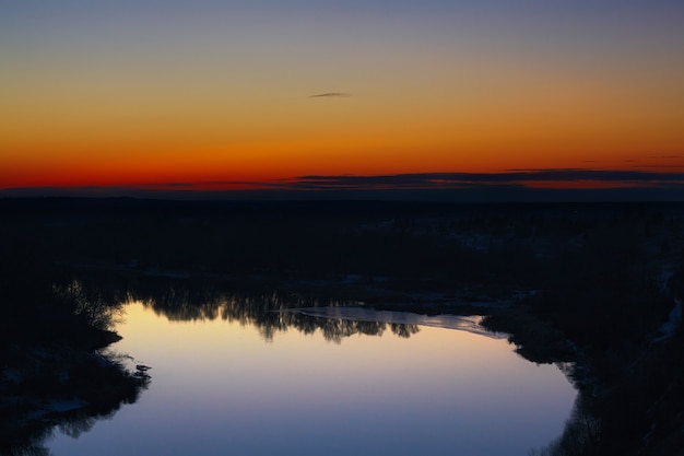 Blick auf den Fluss von der Klippe. Abendhimmel nach Sonnenuntergang.